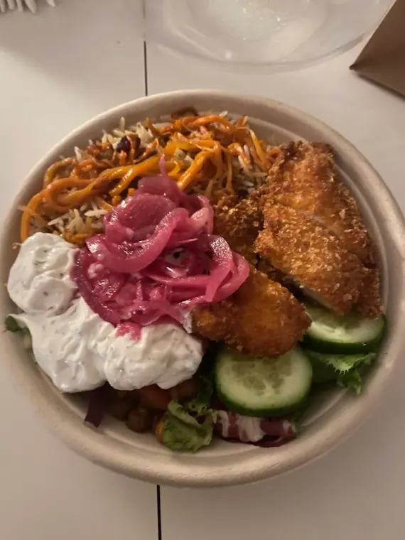 Bowl med panerad kyckling, ris, tzatziki, picklad rödlök och kikärtor